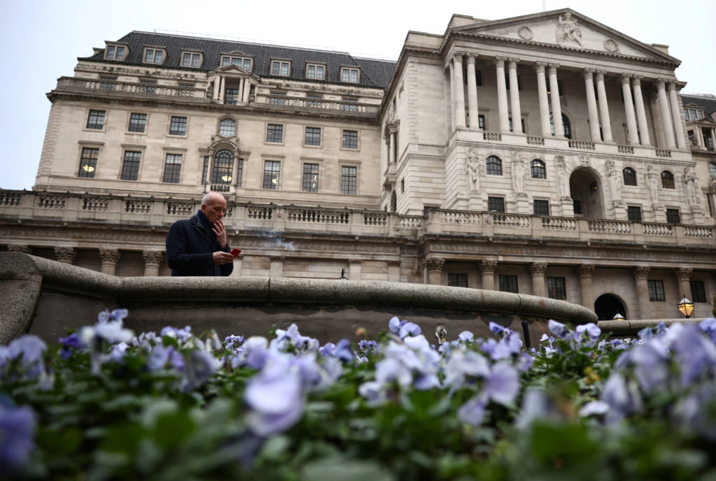 A person smokes a cigarette outside the Bank of England in the City of London financial district, in London