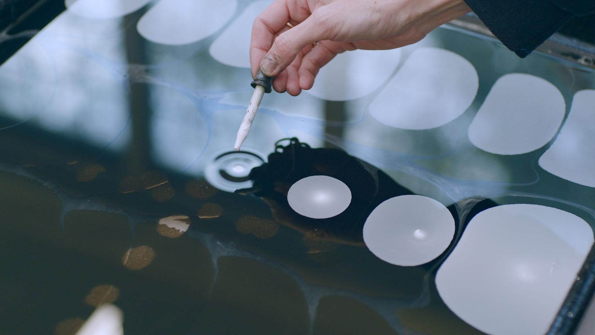 Tauba Auerbach marbling paper in their New York City studio.